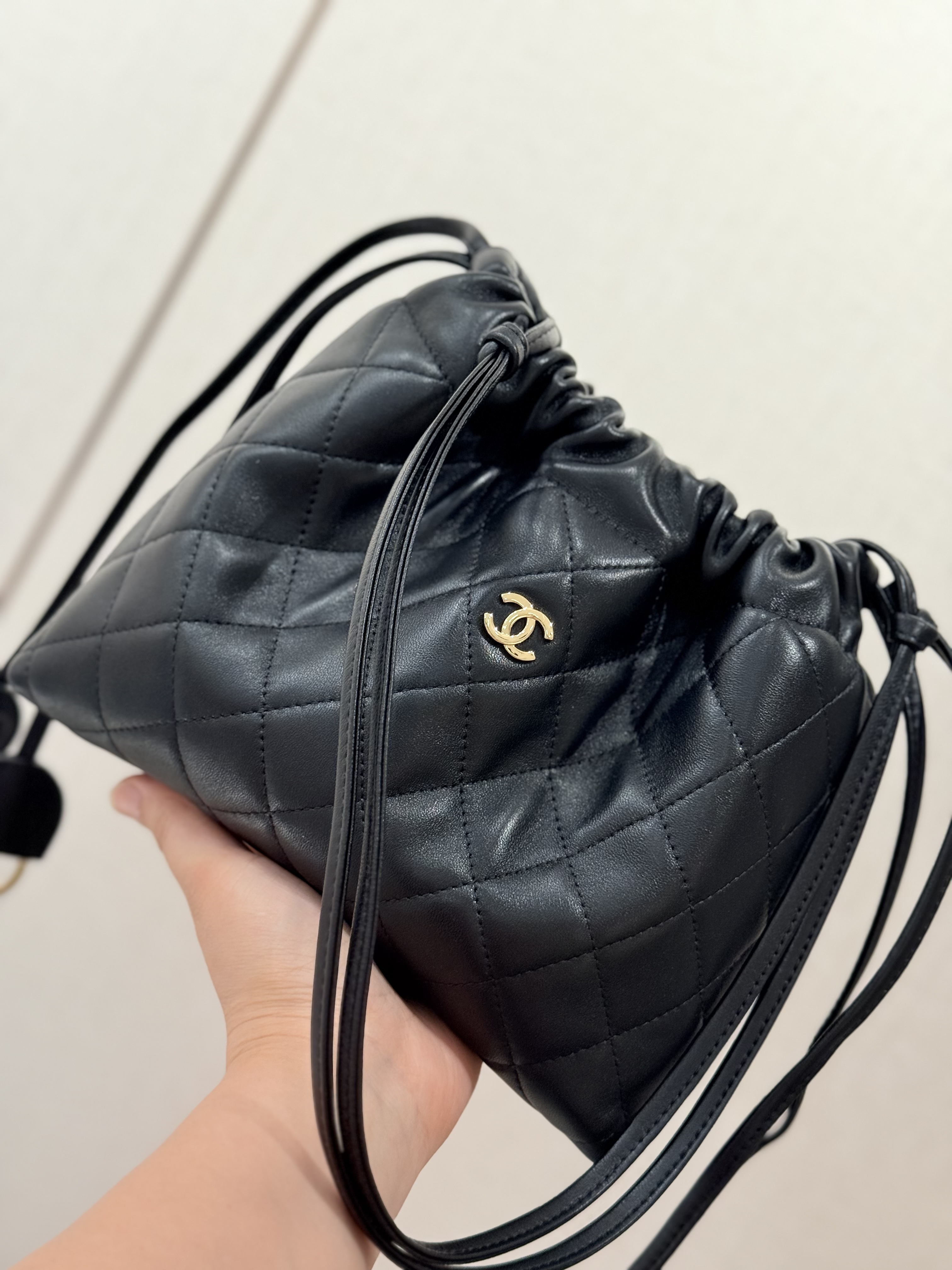 Spring-Summer 2026 Black Quilted Lambskin Mini Drawstring Bucket Bag with Gold-Tone CC Logo - Mocuir
