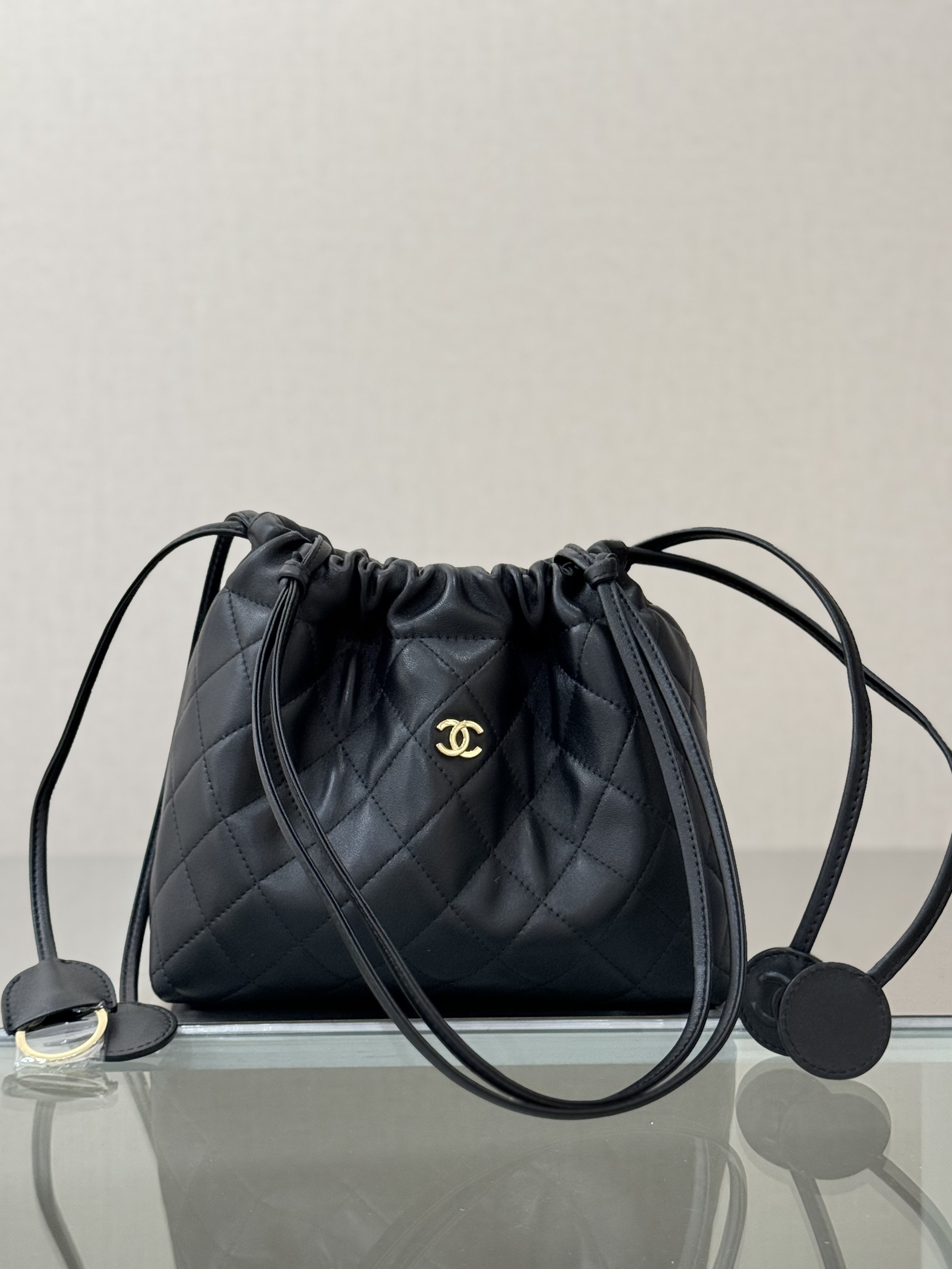 Spring-Summer 2026 Black Quilted Lambskin Mini Drawstring Bucket Bag with Gold-Tone CC Logo - Mocuir
