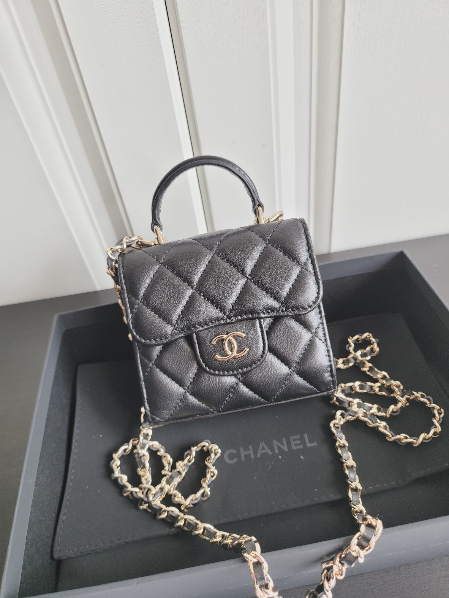 23P Mini Classic Flap Bag with Top Handle in Black Quilted Caviar Leather with Light Gold-Tone Hardware - Mocuir