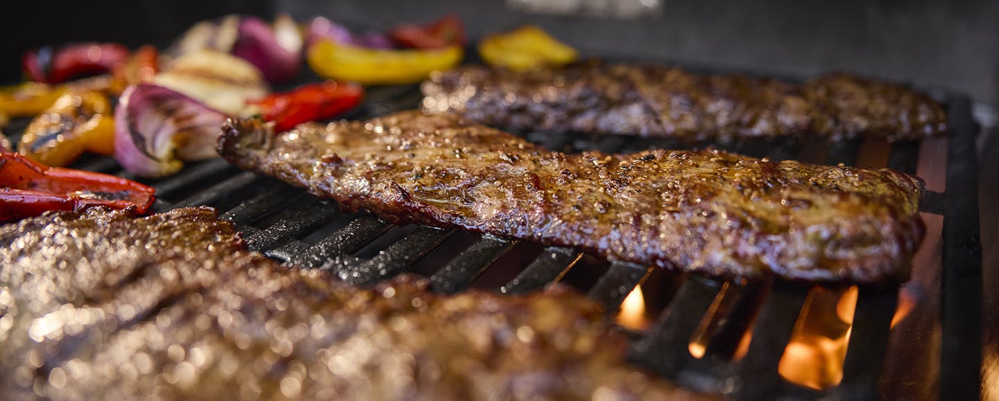 Steak and veggies grilling on a Spirit
